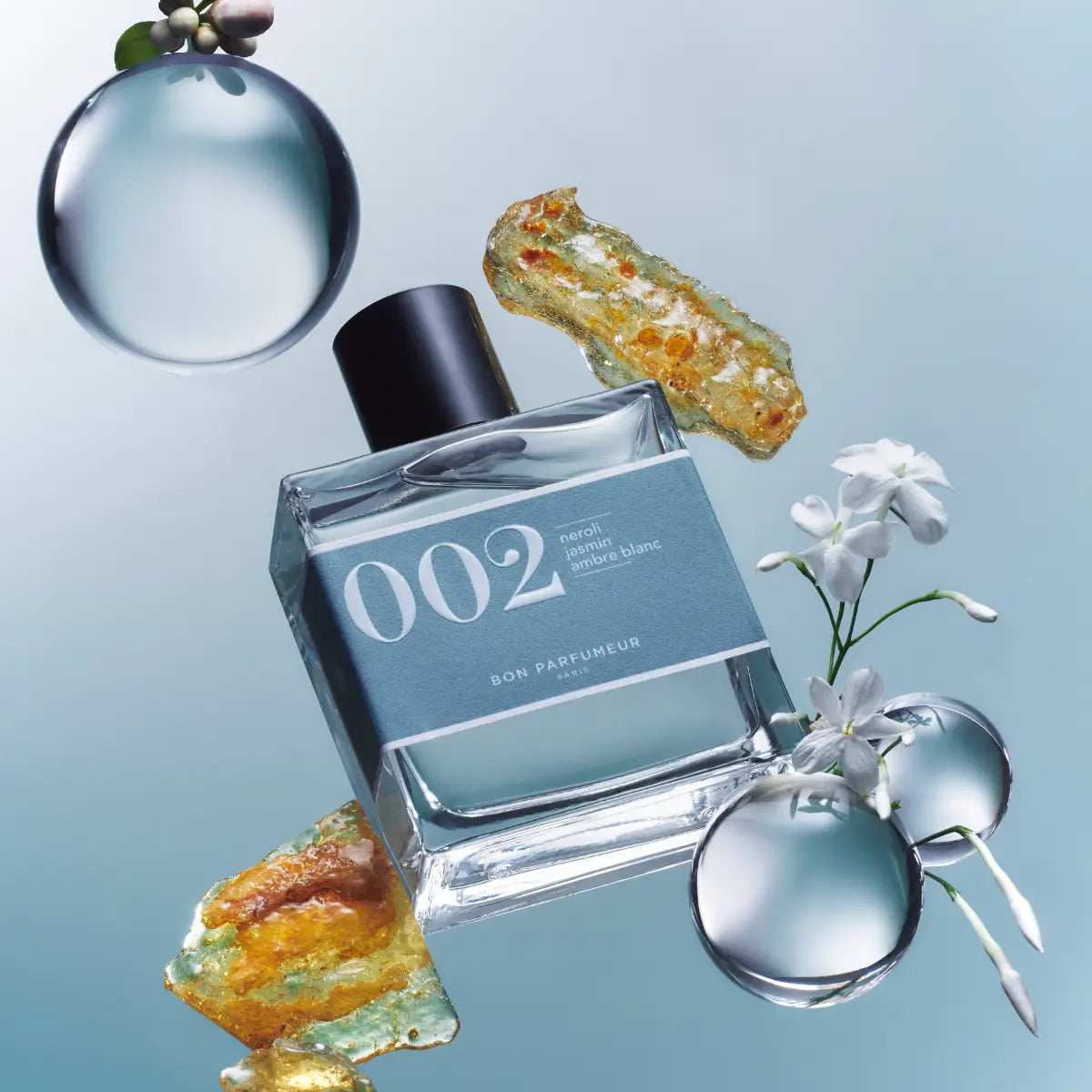 Bon Parfumeur - Les Classiques - 002 Parfümflakon mit blauem Etikett und schwarzem Verschluss vor hellblauem Hintergrund