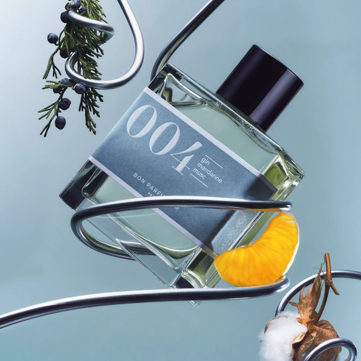 Bon Parfumeur - Les Classiques - 004 Flakon mit blau-grünem Etikett und schwarzem Verschluss vor hellblauem Hintergrund