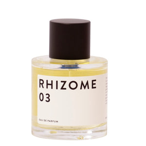 Rhizome - 03 zeigt schlichten Flakon mit weißem Etikett und mattschwarzem Verschluss vor hellem Hintergrund