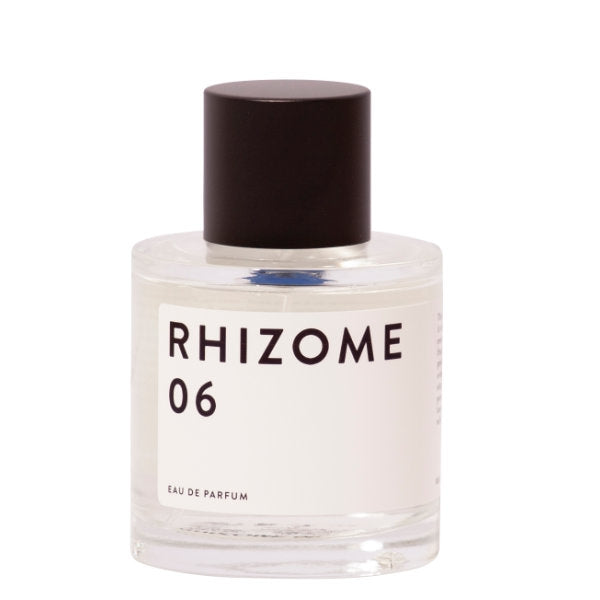 Rhizome - 06 zeigt klaren runden Flakon mit schlichtem weißen Etikett und dunklem Verschluss vor hellem Hintergrund