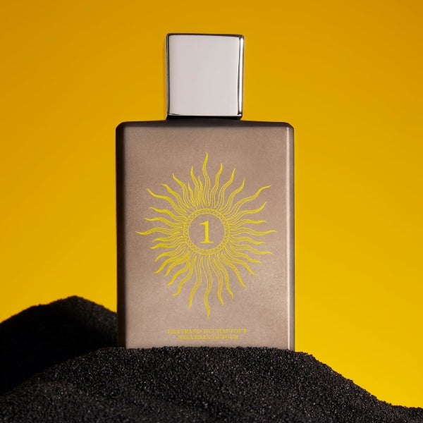 Spiritum - 1 - Solar Soul Parfumflakon mit mattem braunem Design und silbernem Verschluss vor gelbem Hintergrund