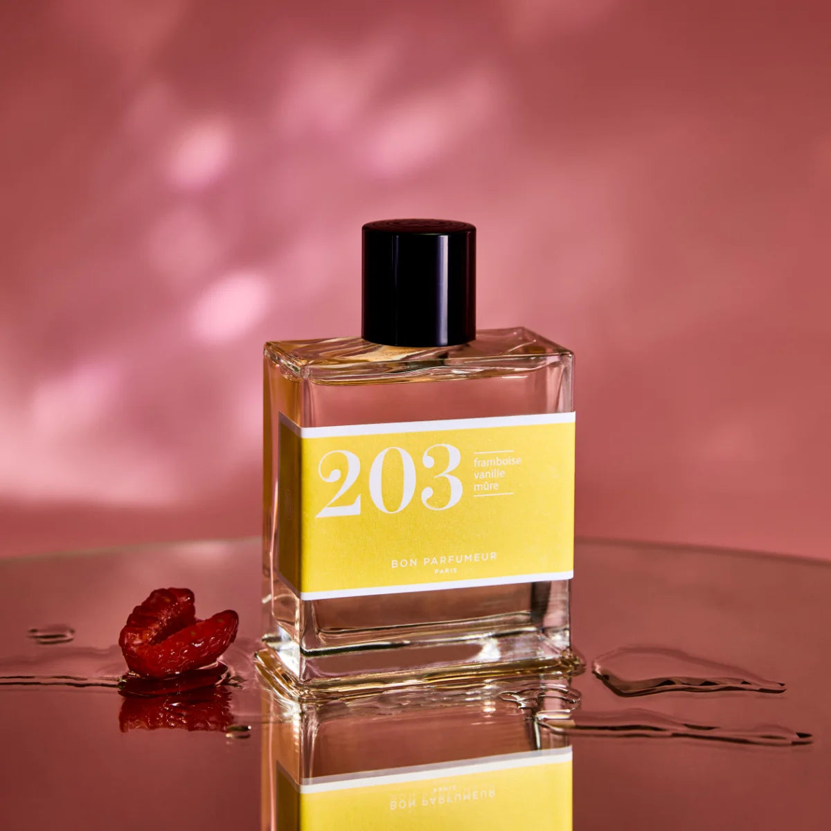 Bon Parfumeur - Les Classiques - 203 Flakon mit gelbem Etikett und schwarzem Verschluss vor rosafarbenem Hintergrund