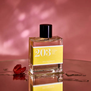 Bon Parfumeur - Les Classiques - 203 Flakon mit gelbem Etikett und schwarzem Verschluss vor rosafarbenem Hintergrund