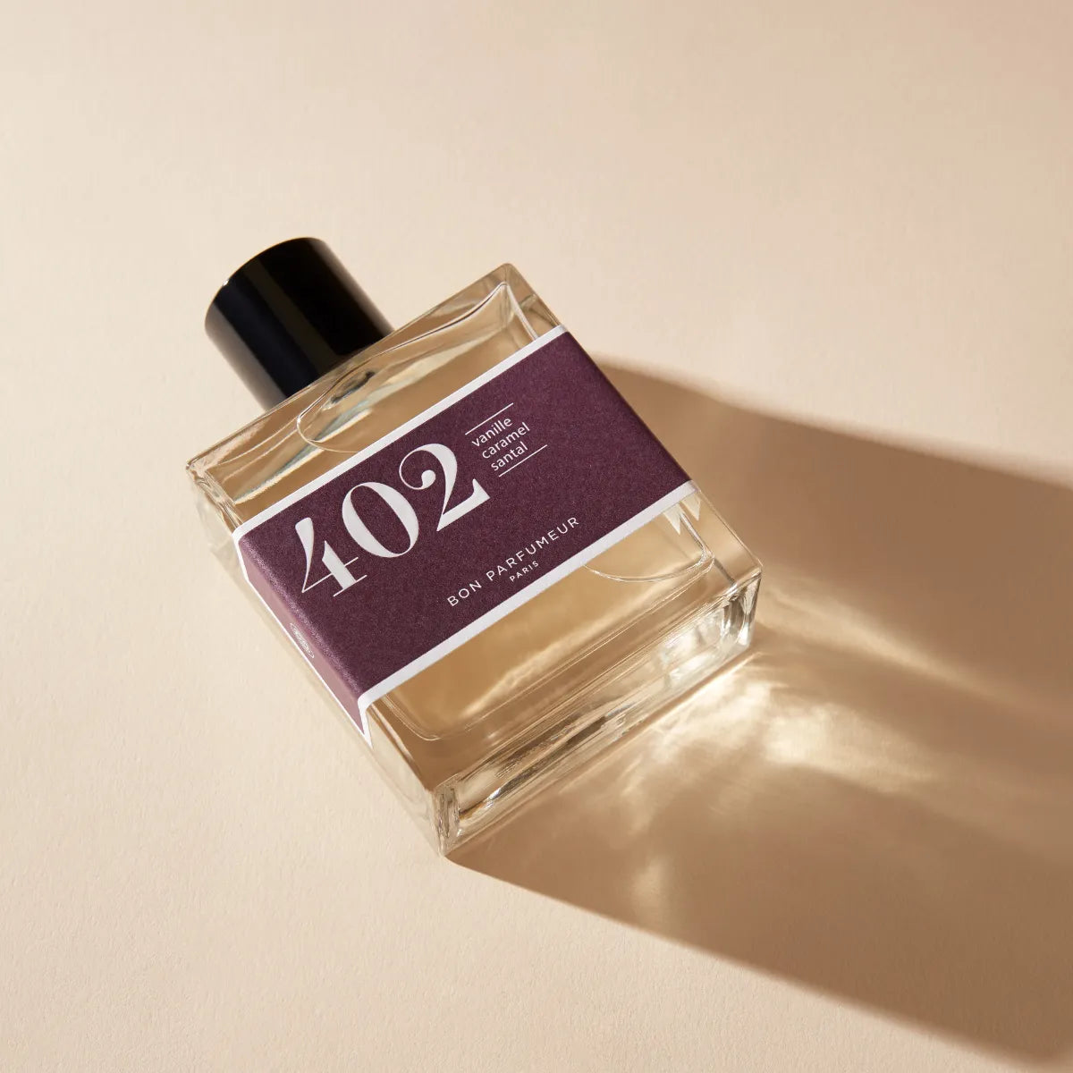 Bon Parfumeur - Les Classiques - 402 Parfumflakon mit lila Etikett und schwarzem Verschluss auf hellbeigem Hintergrund