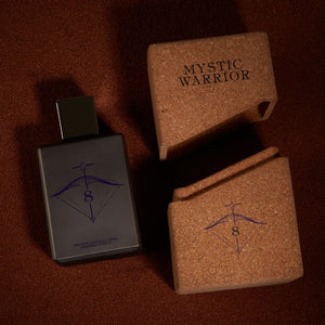 Spiritum - 8 - Mystic Warrior Parfumflakon mit dunklem Design neben Korkverpackung auf braunem Untergrund