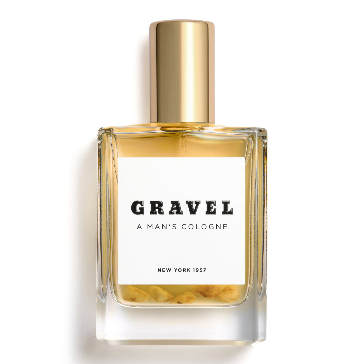 Gravel - A Man's Cologne Parfumflakon mit goldfarbenem Deckel und Kieselsteinen in klarem Glas vor weißem Hintergrund
