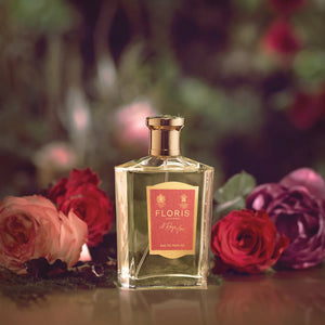Floris - A Rose for... Parfumflakon mit goldenem Verschluss umgeben von Rosen in sanfter Atmosphäre