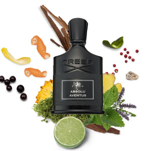 Creed - Absolu Aventus Parfumflakon in mattem Schwarz umgeben von frischen und würzigen Duftnoten