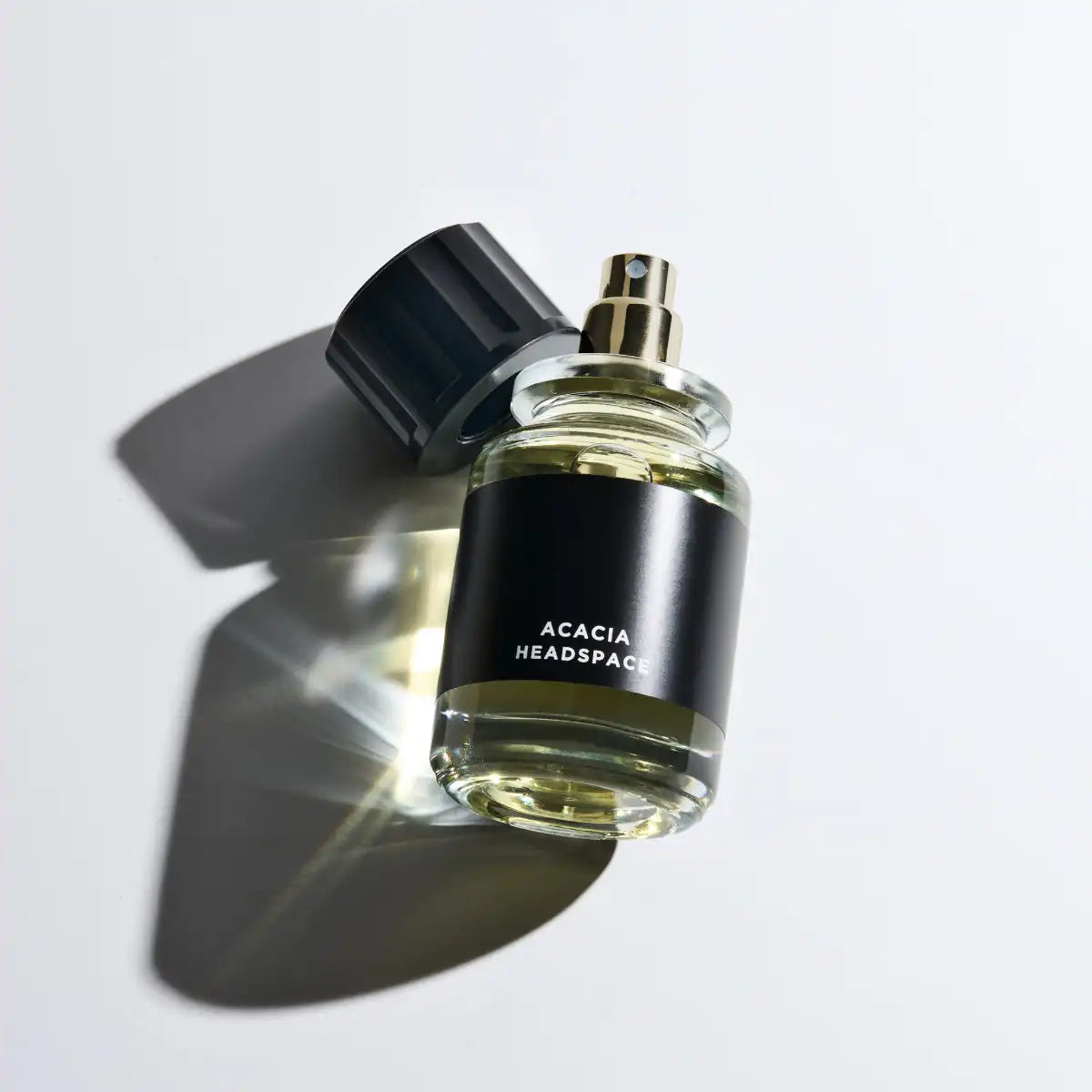 Headspace - Les Extraits - Acacia Parfumzerstäuber mit schwarzem Etikett und transparentem Flakon auf hellem Hintergrund
