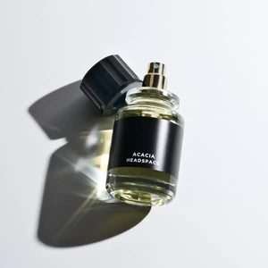 Headspace - Les Extraits - Acacia Parfumzerstäuber mit schwarzem Etikett und transparentem Flakon auf hellem Hintergrund