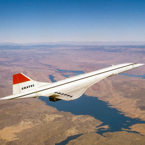 Gravel - Across the Ocean silberner Überschallpassagierjet fliegt über weite, gebirgige Landschaft mit blauem Flussbett