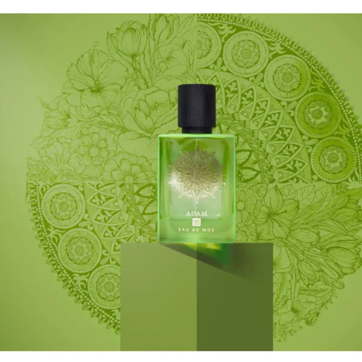 Eau De Moe - Adam Parfümflakon in grünem Glas mit goldenem Mandala und schwarzem Verschluss vor grünem Hintergrund