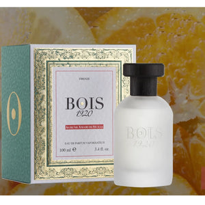 Bois 1920 - Agrumi Amari di Sicilia Parfum mit matter Glasflasche und schwarzem Holzverschluss vor Fruchthintergrund