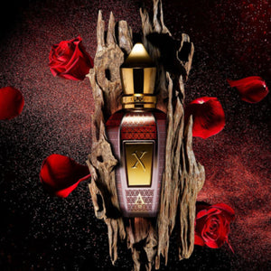 Xerjoff - Oud Stars - Alexandria III Parfumflakon mit goldfarbenem Verschluss umgeben von Rosen und Holztextur