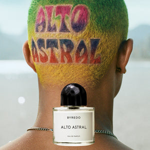 Byredo - Alto Astral Parfumflakon vor Kopf mit farbenfrohem Haarschnitt und Schriftzug im Freien