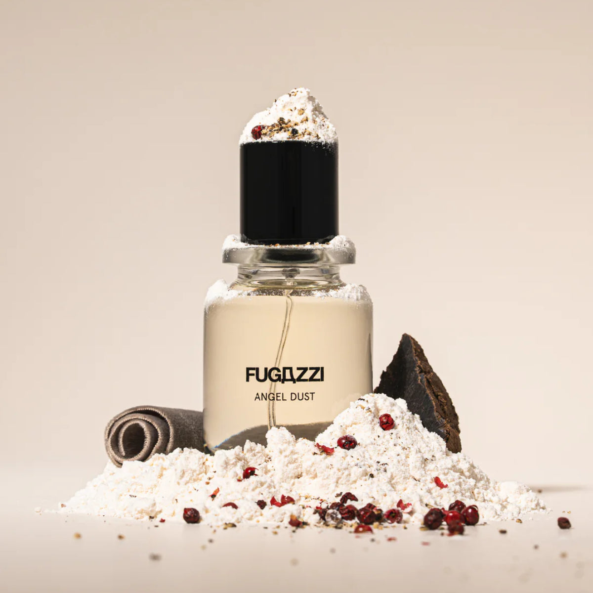 Fugazzi - Angel Dust Extrait Parfümflakon mit schwarzem Deckel umgeben von Gewürzen und weißem Pulver vor hellem Hintergrund