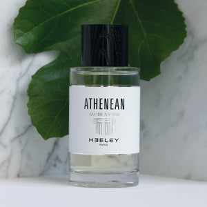 Heeley - Athenean Parfumflakon mit schwarzem Verschluss und minimalistischem Etikett vor grünem Blatthintergrund