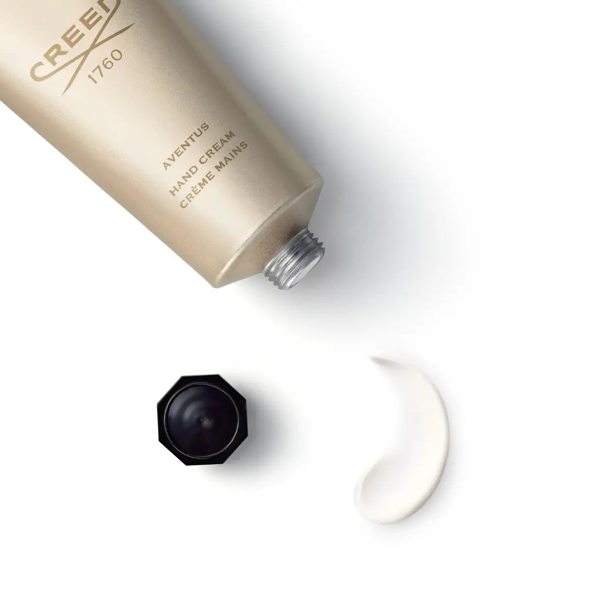 Creed - Aventus - Hand Cream goldfarbene Tube mit schwarzem Deckel und cremiger Textur auf weißem Hintergrund