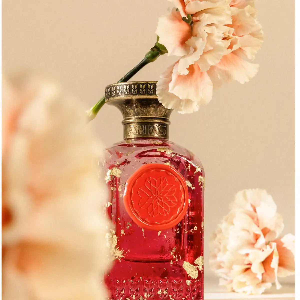 Anfas - Fosol Collection - Aya Parfumflakon mit rotem Siegel und goldenen Details umgeben von zarten Blütenblättern