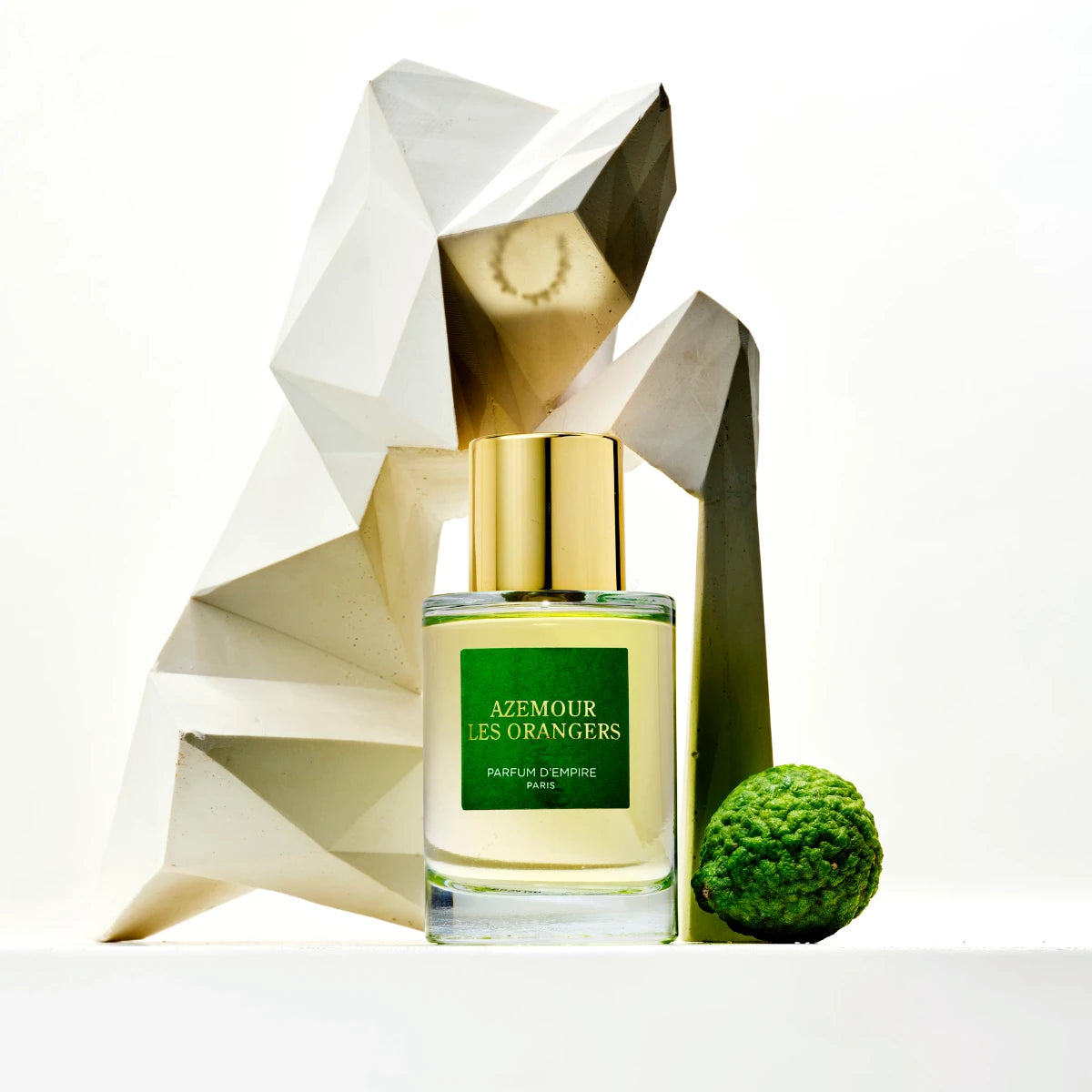 Parfum d'Empire - Azemour Les Orangers Flakon mit grünem Etikett und goldenem Verschluss vor weißer Skulptur