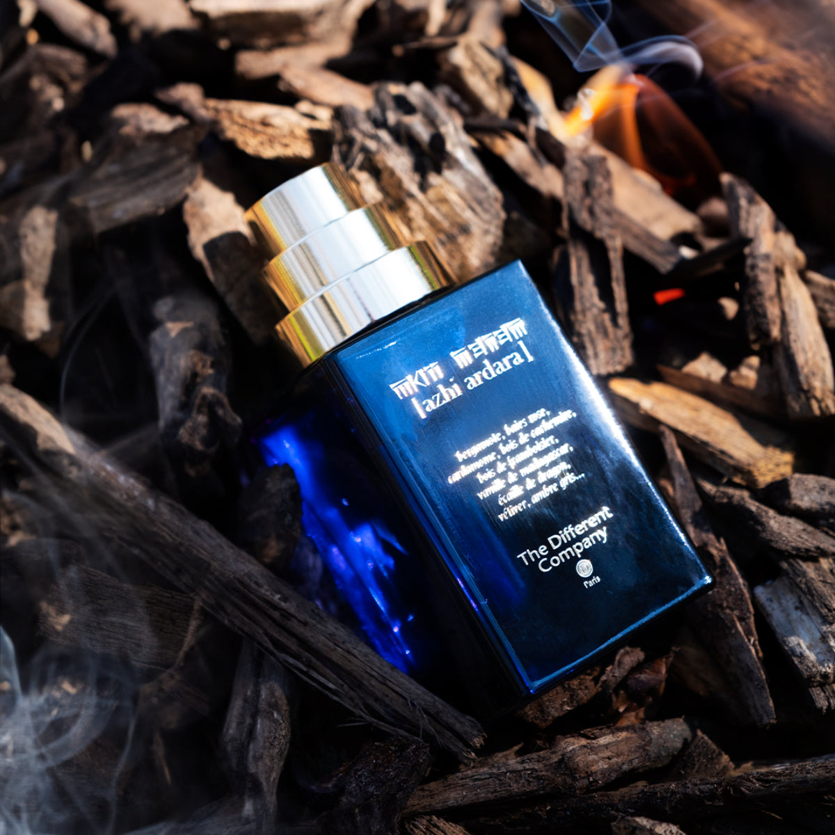 The Different Company - Azhi Ardara Parfumflakon in tiefblauem Glas mit silbernem Zerstäuber auf Holzhintergrund