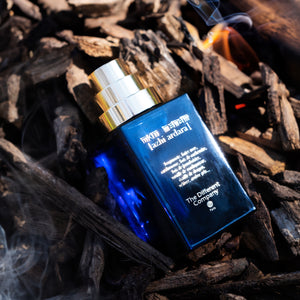 The Different Company - Azhi Ardara Parfumflakon in tiefblauem Glas mit silbernem Zerstäuber auf Holzhintergrund