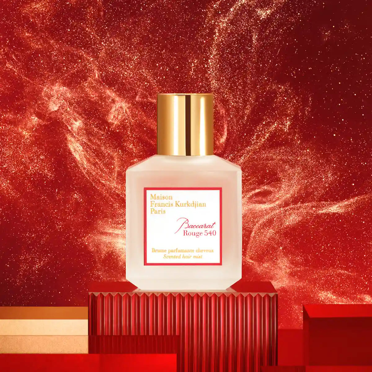 Maison Francis Kurkdjian Paris - Baccarat Rouge 540 - Hair Mist in mattem Flakon mit goldenem Verschluss vor funkelndem rotem Hintergrund