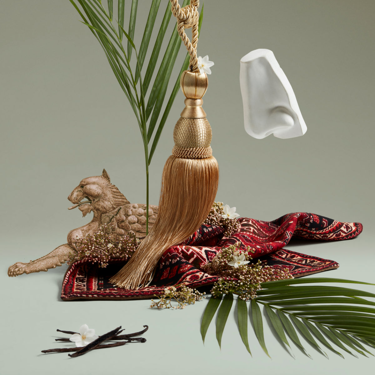 Penhaligon's - Trade Routes - Babylon stilisierte Dekoration mit orientalischem Teppich, goldener Quaste und Pflanzenarrangement
