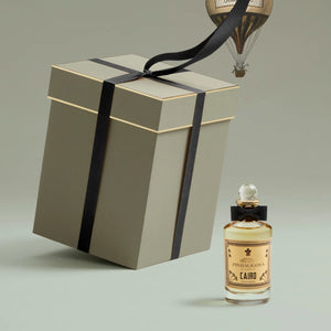 Penhaligon's - Trade Routes - Cairo Duftflakon mit schwarzer Schleife neben eleganter beige Geschenkbox mit schwarzem Band