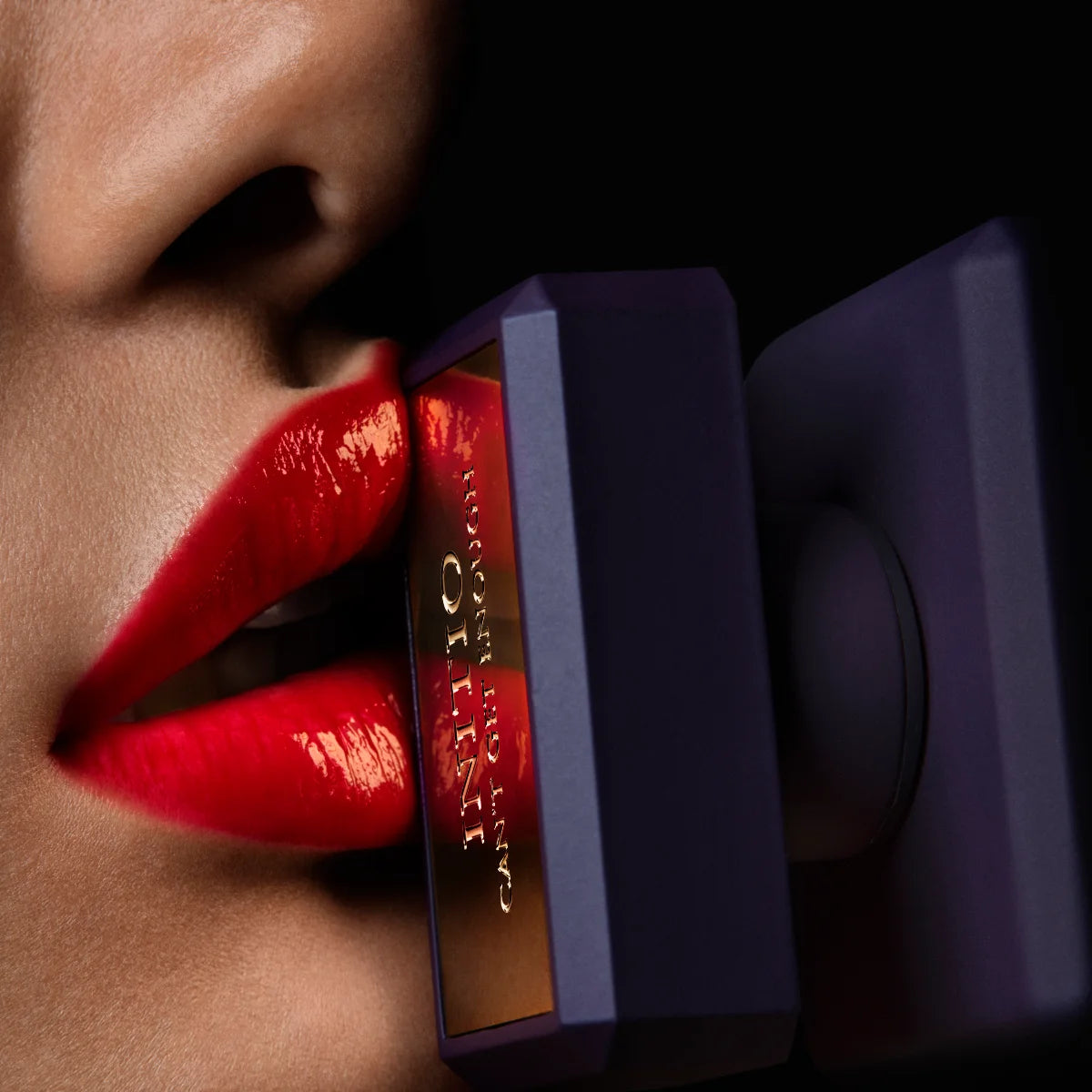 Initio - Carnal Blend - Can't get Enough Nahaufnahme verführerischer roter Lippen mit elegantem Flakon in dunklem Design