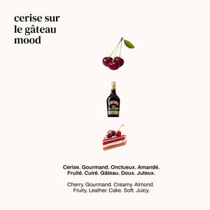 Versatile - Cerise sur le Gâteau mit Kirsche, Likörflasche und Stück Schichttorte auf hellem Hintergrund
