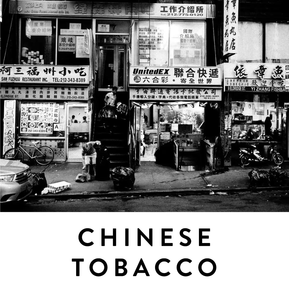 19-69 - Chinese Tobacco Schwarz-Weiß-Fotografie eines asiatischen Straßenzugs mit Geschäften und urbanem Flair