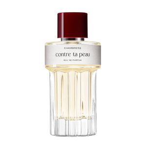 Chambre52 - Contre ta Peau zeigt eleganten Flakon mit hellem Parfum und tiefrotem Verschluss vor weißem Hintergrund