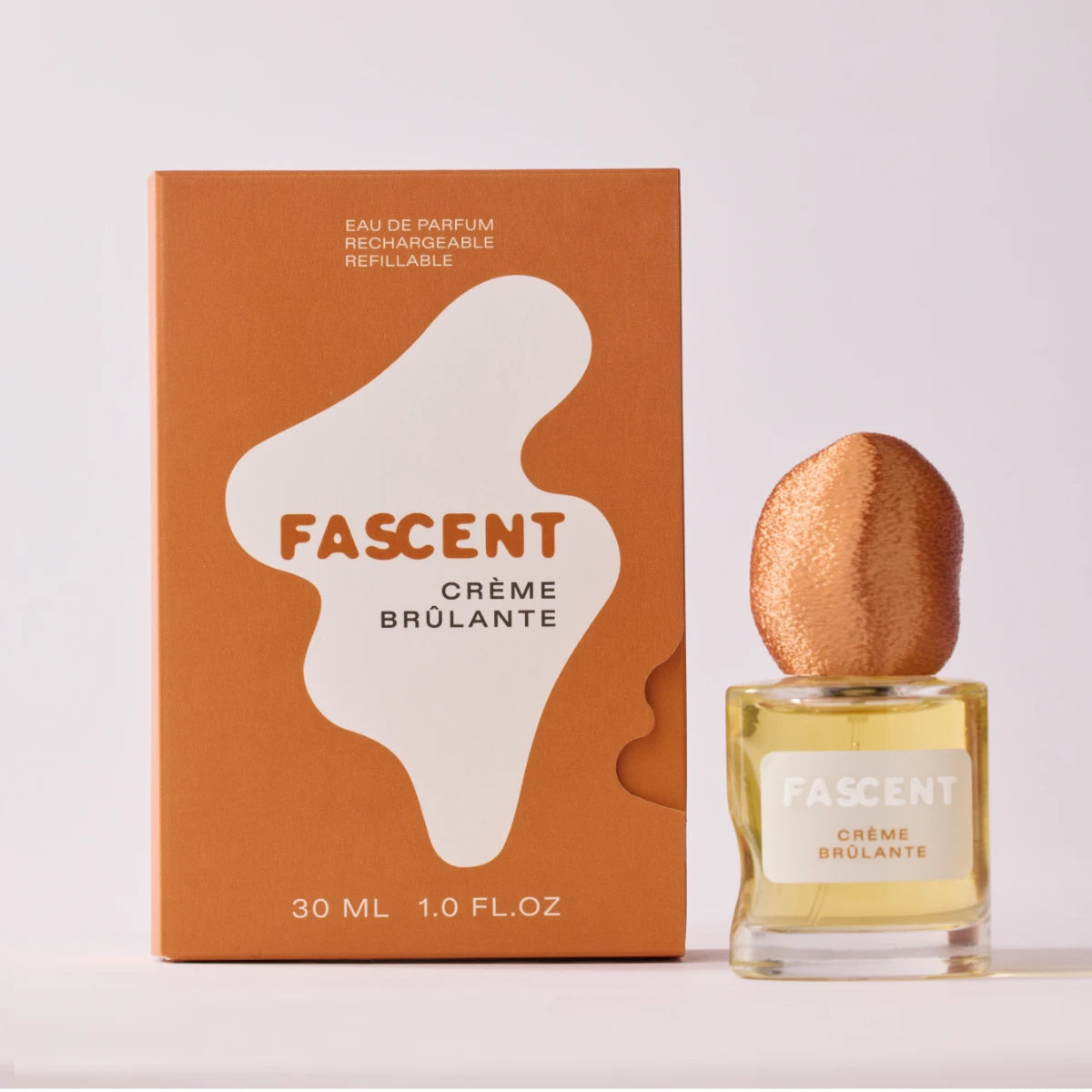 Fascent - Crème Brûlante Parfumflakon mit markantem kupferfarbenem Deckel und orangefarbener Verpackung vor hellem Hintergrund