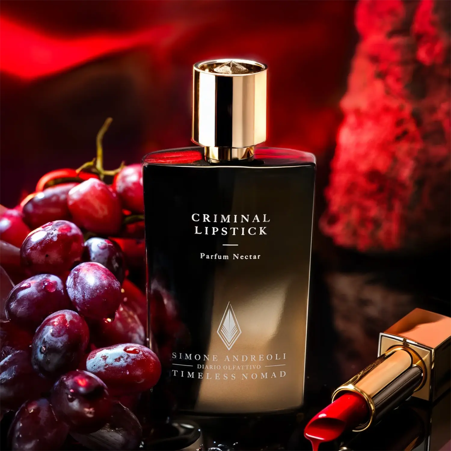 Simone Andreoli - Criminal Lipstick Parfumflakon mit goldenem Deckel neben rotem Lippenstift und Traubenarrangement