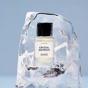 Matière Première - Crystal Saffron zeigt eleganten Flakon mit schwarzem Deckel in klarem Eisblock vor blauem Hintergrund