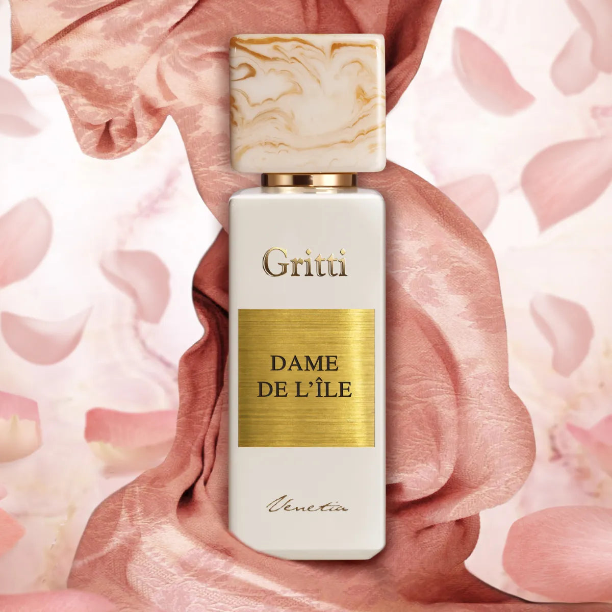 Gritti - White Collection - Dame de L'Île Parfumflakon mit goldenem Label und marmoriertem Verschluss vor zart rosa Samt und Blütenblättern