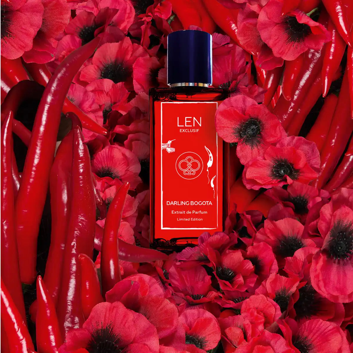 LEN - Darling Bogota roter Parfumflakon umgeben von roten Chili-Schoten und leuchtend roten Mohnblumen in Nahaufnahme