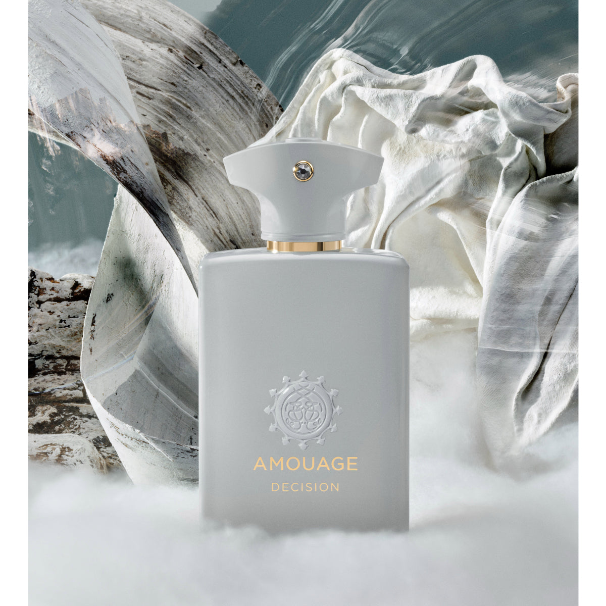 Amouage - Decision Flakon in elegantem Weiß mit goldenen Details vor künstlerischem Hintergrund aus Stoff und Holz