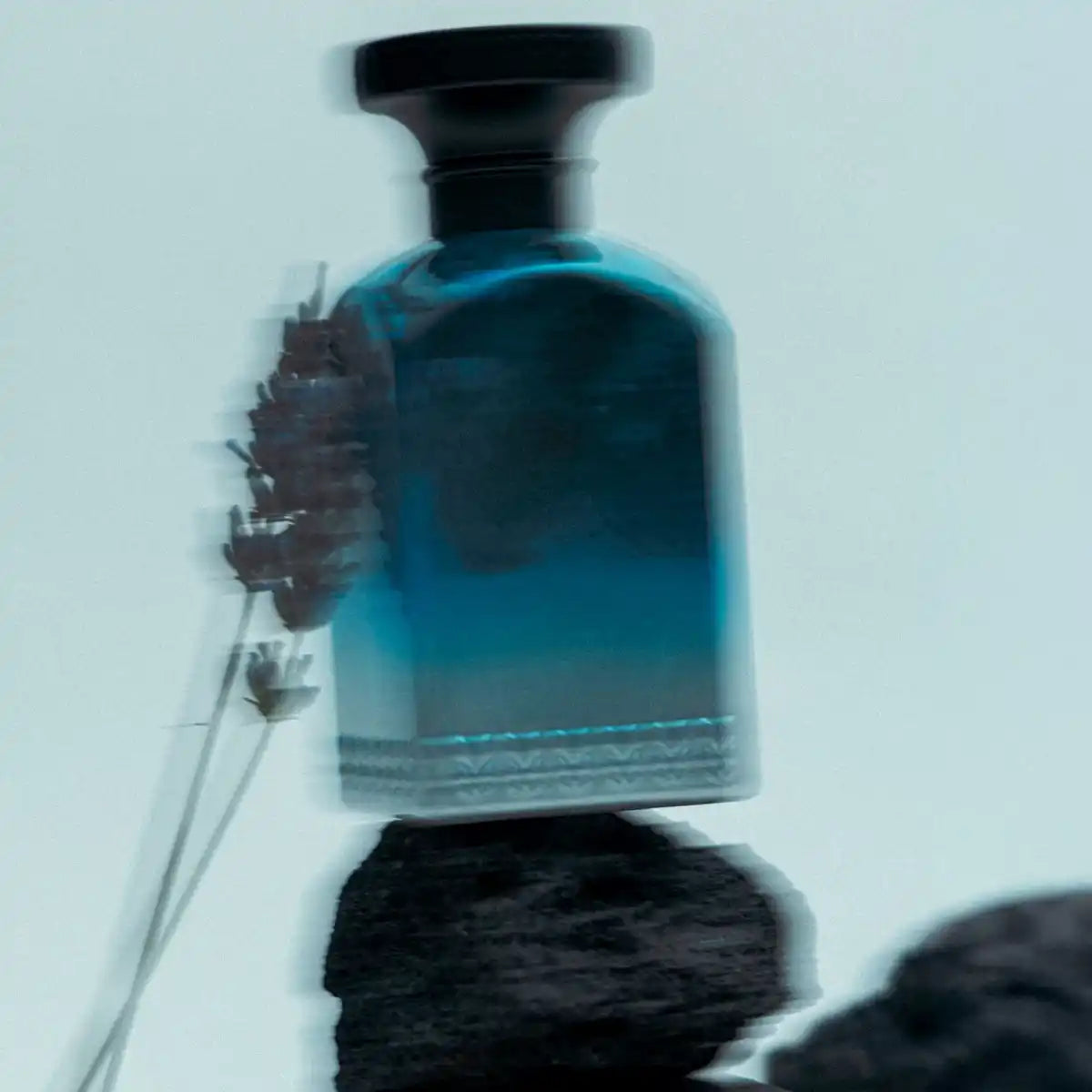 Anfas - Fosol Collection - Dhai Parfumflakon in kühlem Blau mit schwarzem Verschluss vor minimalistischer Kulisse