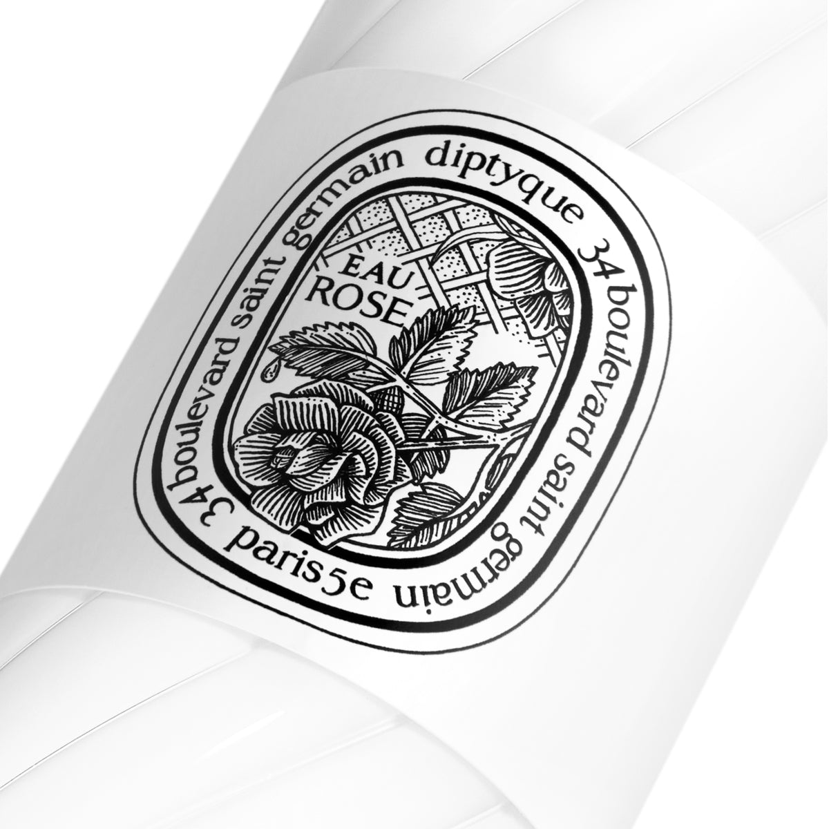 Diptyque - Eau Rose - Hand & Body Lotion mit stilvollem, schwarzem Blumen-Label auf cremeweißer Flasche, Nahaufnahme