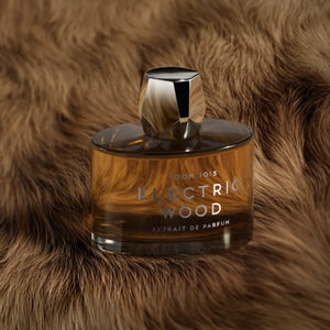 Room 1015 - Electric Wood - Extrait Parfumflakon mit kantigem Verschluss auf weichem, braunem Fellhintergrund