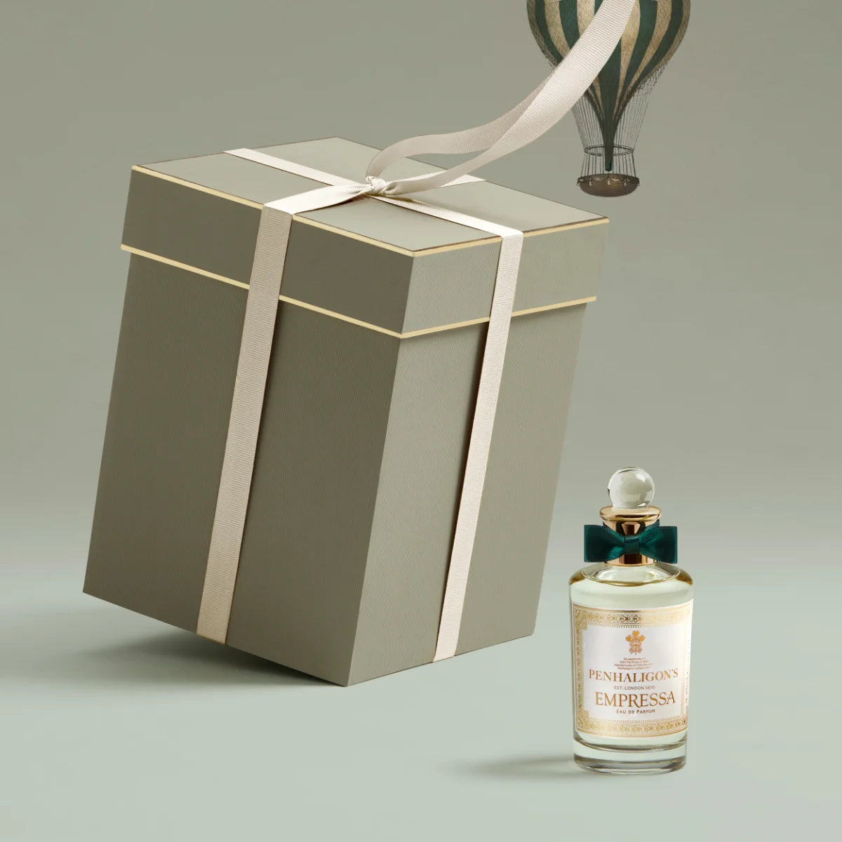 Penhaligon's - Trade Routes - Empressa Parfumflakon mit Schleife neben elegantem Geschenkbox und Heißluftballon im Hintergrund