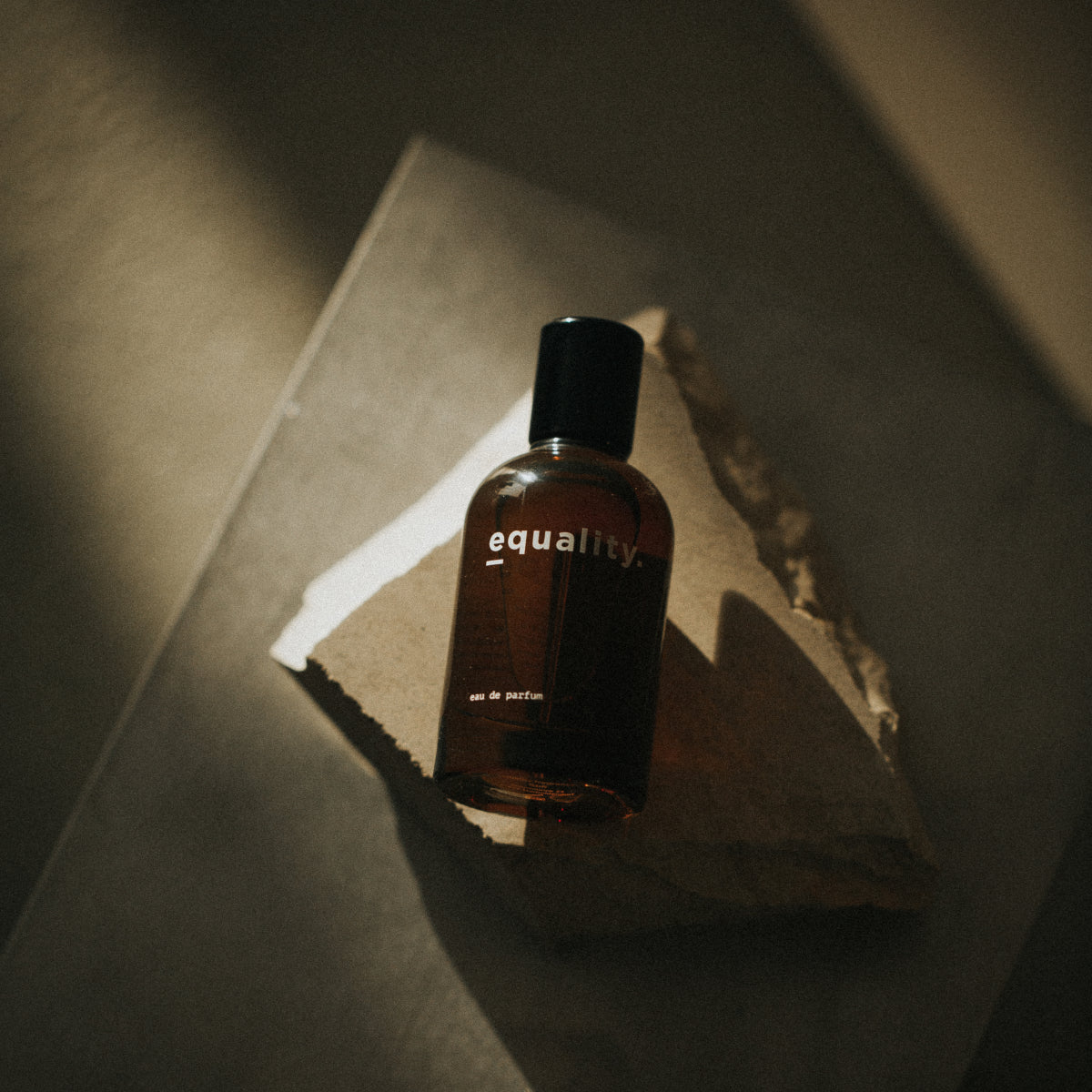 equality. fragrances - equality. Parfumflakon in dunklem Bernstein mit schlichtem schwarzem Verschluss und minimalistischem Design