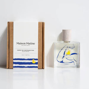 Maison Matine - Esprit de Contradiction Parfumflakon mit klarer Flasche, blauem Armmotiv und gelbem Entchen vor einfacher Verpackung