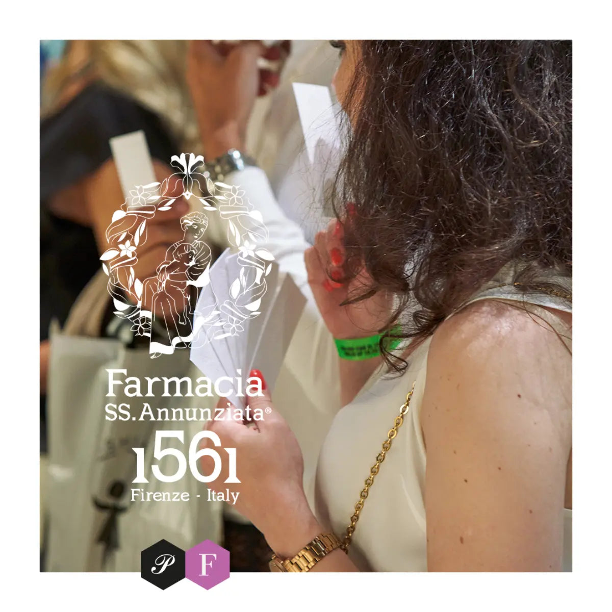 Farmacia SS. Annunziata - Oud E Rosa Nera Glas mit elegantem Logo-Design vor unscharfem Hintergrund einer Person in Weiß