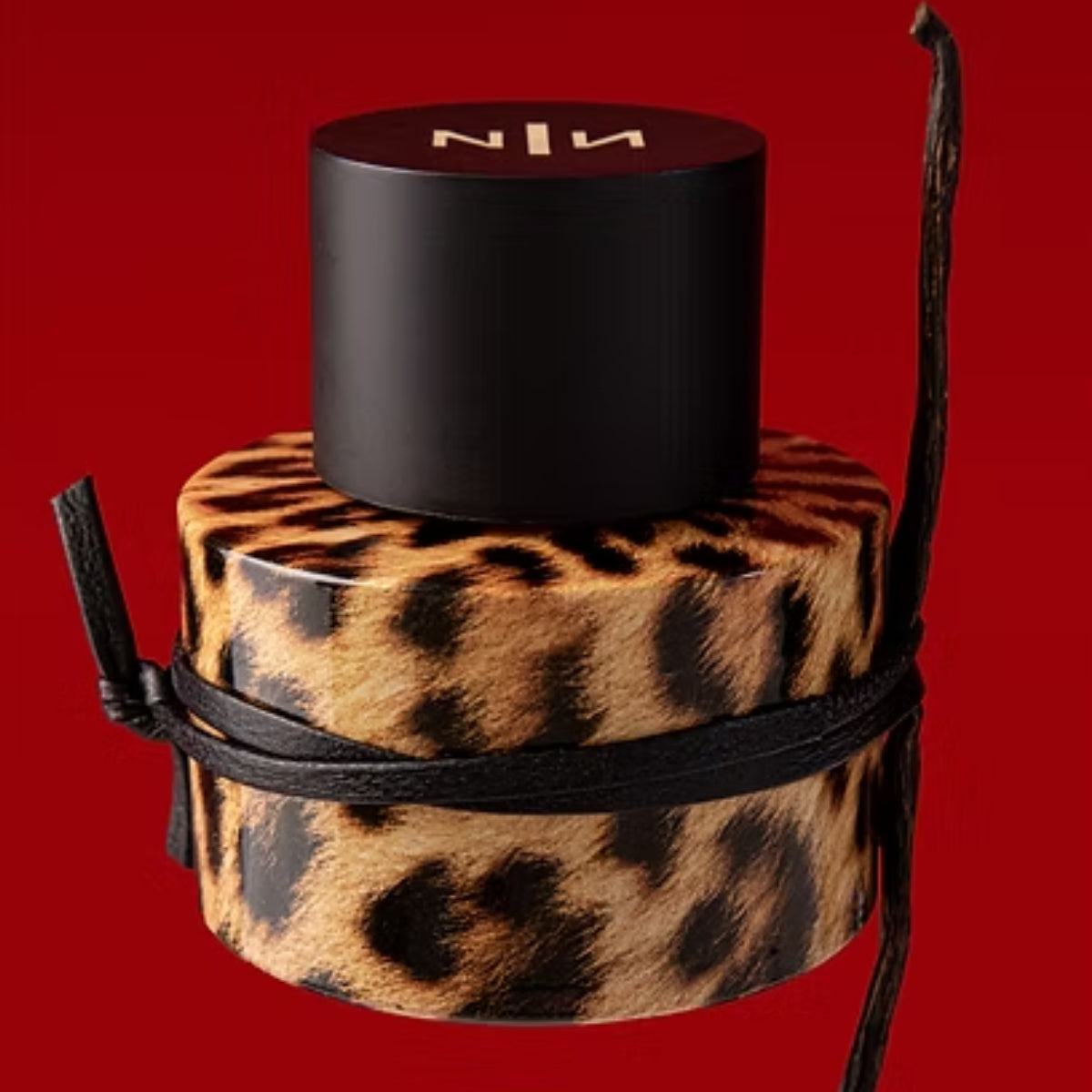New Notes - Modern Liquid Collection - Felina Parfumbehälter mit Leopardenfellmuster und schwarzem Deckel vor rotem Hintergrund