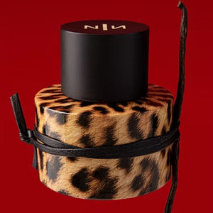 New Notes - Modern Liquid Collection - Felina Parfumbehälter mit Leopardenfellmuster und schwarzem Deckel vor rotem Hintergrund