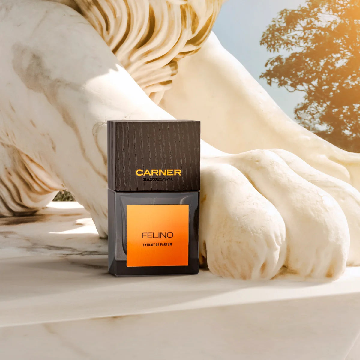 Carner Barcelona - Bestial Collection - Felino Parfumflakon mit schwarzem Deckel und orangefarbenem Etikett neben Löwenskulptur