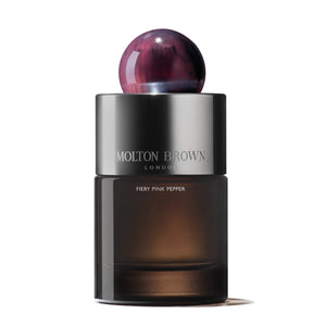 Molton Brown - Fiery Pink Pepper Parfumflakon mit rauchigem Glas und dunkelrotem, marmoriertem Rundverschluss vor weißem Hintergrund